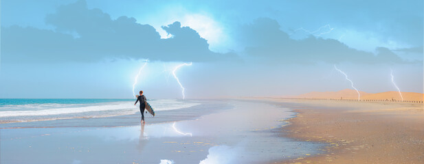 A young man surfer walks on the beach with a surfboard in hand lightning in the background -...