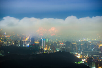 Fototapeta na wymiar Nighttime Vista: Captivating City Lights and the Playful Dance of Clouds. View of the urban landscape from Dajianshan Mountain, New Taipei City, Taiwan.