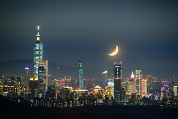 Moonlit Urban Nights: The Beauty of City Lights and a Shining Moon. Enjoy the night view of Taipei City from Neihu Bishanyan Temple.