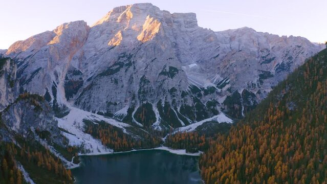 4k drone flight up footage (Ultra High Definition) of Braies Lake with Seekofel Croda del Becco on background. Aerial autumn scene from flying drone of Dolomite Alps, Italy, Europe.