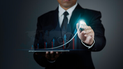 Businessman is using stylus pen writing arrow graph corporate future growth plan. Business...