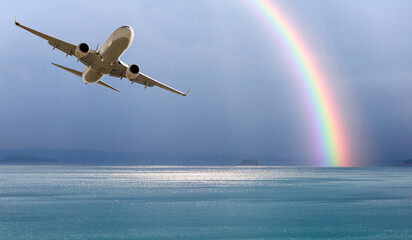 White passenger airplane under the clouds with amazing ring rainbow - Travel by air transport