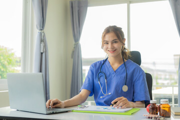 Female doctor chats online with patient Attractive female doctor working remotely from hospital in office and transfer diagnostic treatment to sick people online