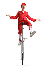 Entertainer in a red suit riding a unicycle