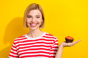 Portrait of positive cheerful girl with bob hairstyle wear stylish t-shirt arm hold yummy muffin...