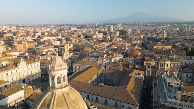 Amazing Aerial View of Domed Cathedral in Catania, Italy with Famous Mount Etna Volcano in Background
