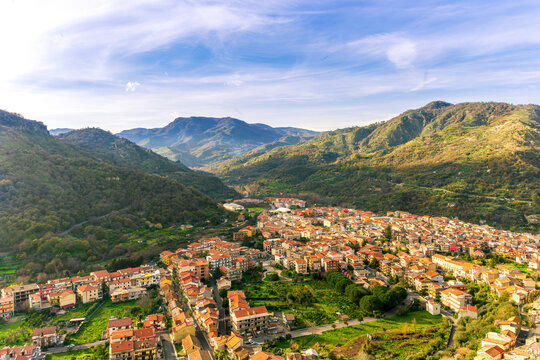 amazing mountain travel landscape of view on highland valley town with mountains and beautiful cloudy sunset on background