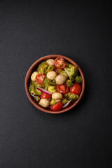 Delicious fresh salad with broccoli, cherry tomatoes, mushrooms, onions, salt, spices and herbs