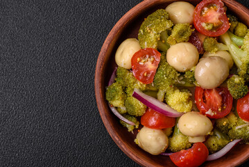 Delicious fresh salad with broccoli, cherry tomatoes, mushrooms, onions, salt, spices and herbs