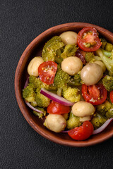 Delicious fresh salad with broccoli, cherry tomatoes, mushrooms, onions, salt, spices and herbs