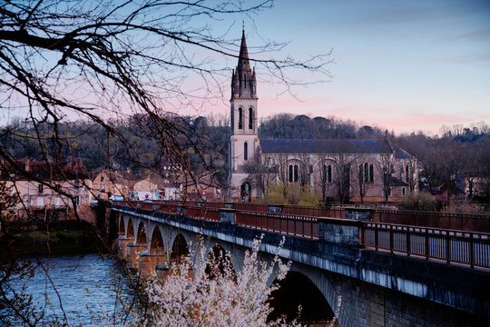 View of the Lalinde bridge and church from the bridge at sunset