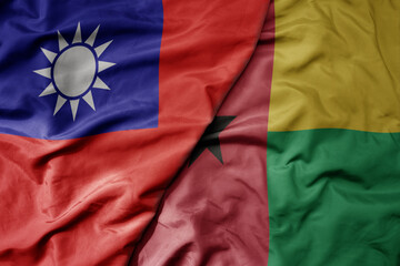 big waving national colorful flag of taiwan and national flag of guinea bissau .
