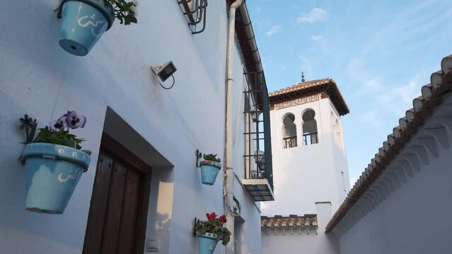 Tower of Great Mosque and flowery facade in the Albaicin in Granada, Spain