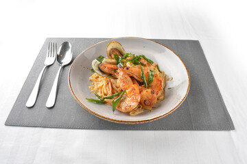 seafood pasta with big tiger prawn, scallop shell clam and muscle in olive oil salted egg yolk paste sauce in plate on white marble table western spaghetti cuisine halal food hotel luxury cafe  menu