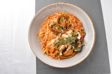 seafood pasta with big tiger prawn, scallop shell clam and muscle in spicy chilli crab tomato paste sauce in plate on white marble table western spaghetti cuisine halal food hotel luxury cafe menu © perfectloop