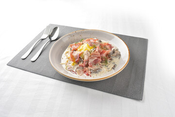carbonara pasta noodle with bacon, ham and half boiled egg in creamy cheese white milk sauce in plate on white marble table western spaghetti cuisine halal food hotel luxury cafe menu