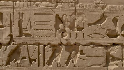 Wall of hieroglyphics at Karnac temple, Egypt.  Strong carved relief of the symbols important to the ancient Egyptian culture. Day.