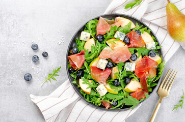 Salad with Pear, Arugula, Jamon, Blue Cheese and Blueberry, Delicious Fresh Salad on Bright Background