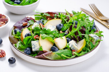 Salad with Pear, Arugula, Blue Cheese and Blueberry, Delicious Fresh Salad on Bright Background