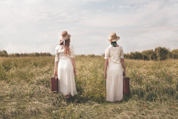 two surreal female traveler dressed alike with suitcase are ready for their adventure journey together, abstract concept - 643576733