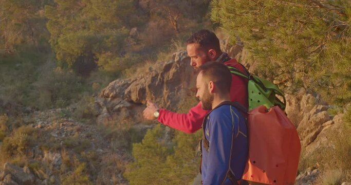 Two mountaineers discussing the route to follow, they watch the sun rising in the distance, Orihuela, Alicante, Spain - stock video