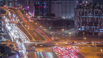 Top aerial view of busy road intersection and traffic junctions in Dubai city night timelapse.