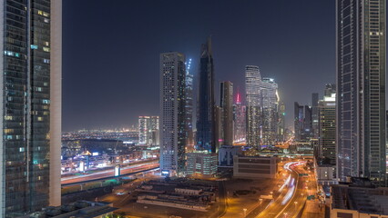 Fototapeta na wymiar Many towers and skyscrapers with traffic on streets in Dubai Downtown and financial district night timelapse.