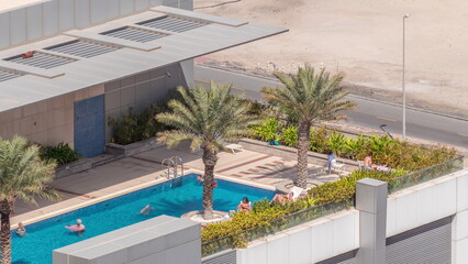 Fototapeta na wymiar Luxury swimming pool on roof top during amazing sunny day aerial timelapse.