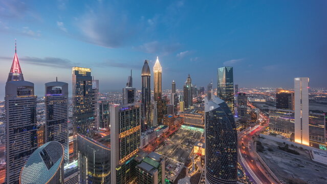 Fototapeta Skyline view of the high-rise buildings on Sheikh Zayed Road in Dubai aerial day to night timelapse, UAE.