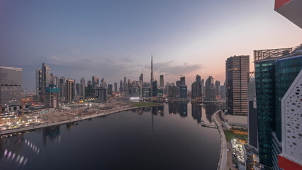 Aerial panorama of Dubai Business Bay and Downtown with the various skyscrapers and towers night to day timelapse