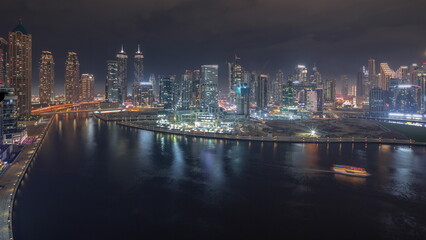 Cityscape with skyscrapers of Dubai Business Bay and water canal aerial night timelapse.