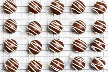 Making and decorating delicious homemade sweet balls with dark and white chocolate.