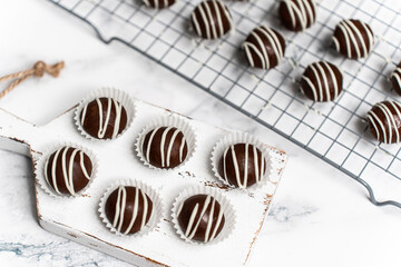 Making and decorating delicious homemade sweet balls with dark and white chocolate.