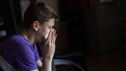 A teenage boy uses an allergy and asthma inhaler