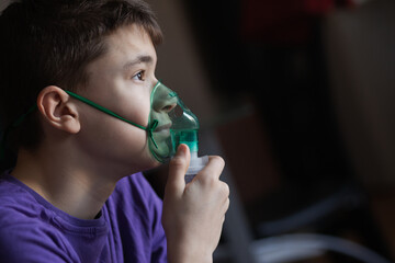 A teenage boy uses an allergy and asthma inhaler
