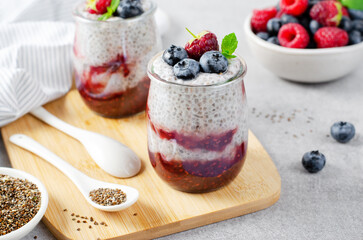 Healthy Chia Pudding in a Glass with Raspberry Jam and Fresh Berries