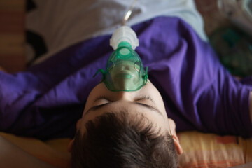 A teenage boy uses an allergy and asthma inhaler