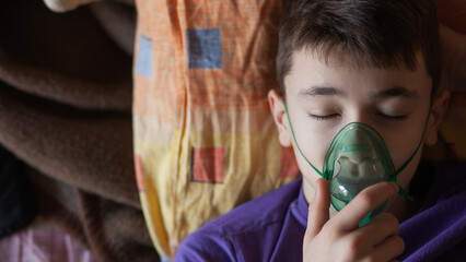 A teenage boy uses an allergy and asthma inhaler