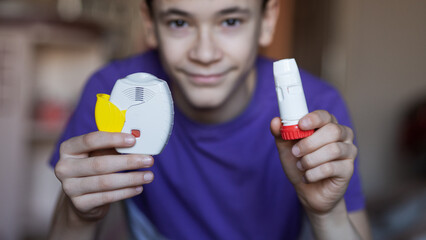 A teenage boy uses an allergy and asthma inhaler