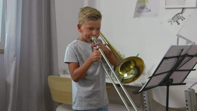 Committed young boy practicing trombone.