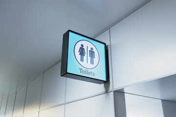 A glowing sign indicating the entrance to the airport lavatory facilities. WC
