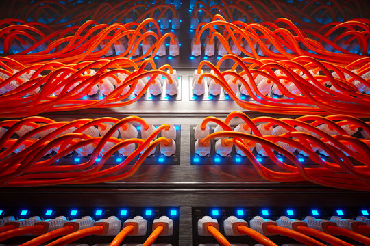 Countless orange cables in a metal server cabinet lit by a single spotlight.