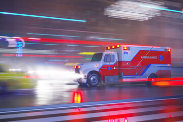 An emergency ambulance on the signal goes through a city streets during night. © Dabarti