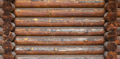A log wall construction with a swedish cope log profile. Dirty and heavily cracked wall of a blockhouse as a background
