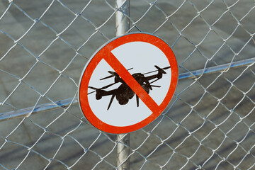 No Drones Zone sign on airport fence. A warning for unauthorized aerial vehicles