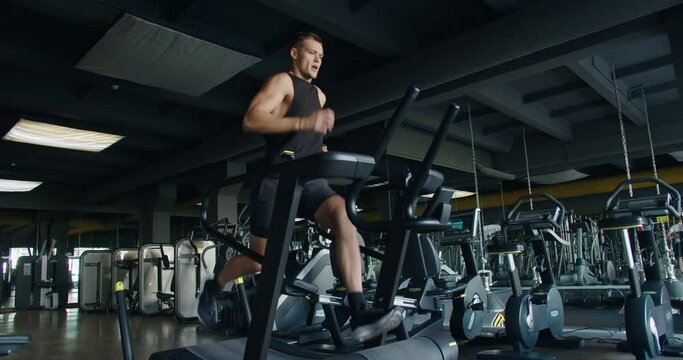 Strong athletic man doing intense cardio workout and running fast on treadmill at fitness club. Active sportsman male jogging at modern gym. Healthy lifestyle concept