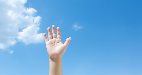 children's hand against the sky clenched into a fist