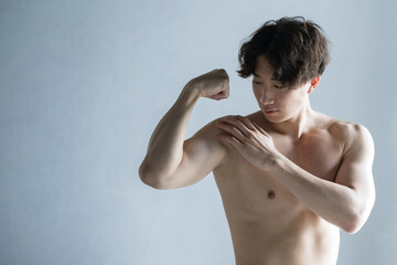 筋肉を鍛えるカッコイイハンサムな日本人男性　上腕二頭筋や胸筋