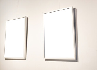 Blank picture frames on grey wall with glowing lamp, mock up