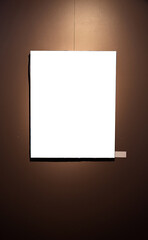 Blank picture frames on brown wall with glowing lamp, mock up